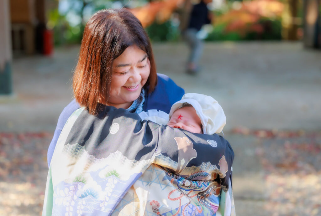 奈良県吉野郡 波比賣神社で産着に包まれ祖母に抱かれたお宮参りの男の子