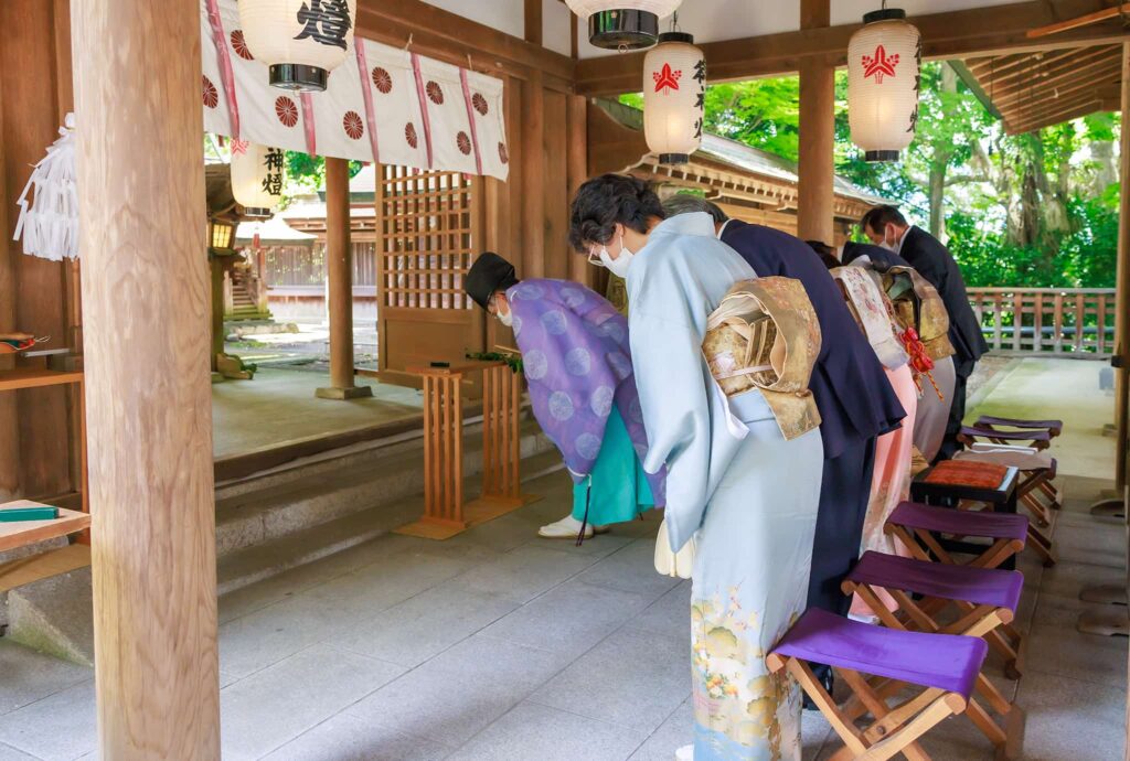 五條市御霊神社で男の子のお宮まいりで神職と参列者が一同礼をしている