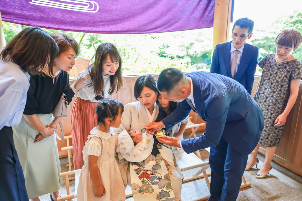 高鴨神社の拝殿でお宮参りの男の子を親族が囲んで微笑ましく見ている様